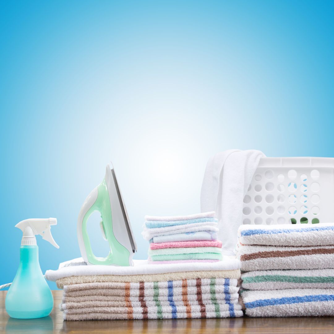 Set de lavandería con plancha, rociador y toallas blancas limpias